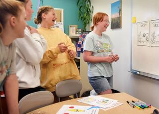 Samantha Davis, right, shares a laugh with her fellow students at Newton Christian School after receiving feedback for the children's book they are all working on.