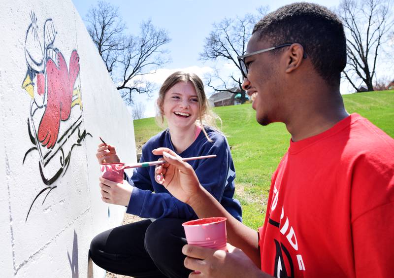 Students paint a mural during Red Pride Service Day on May 4 at Sunset Park in Newton.