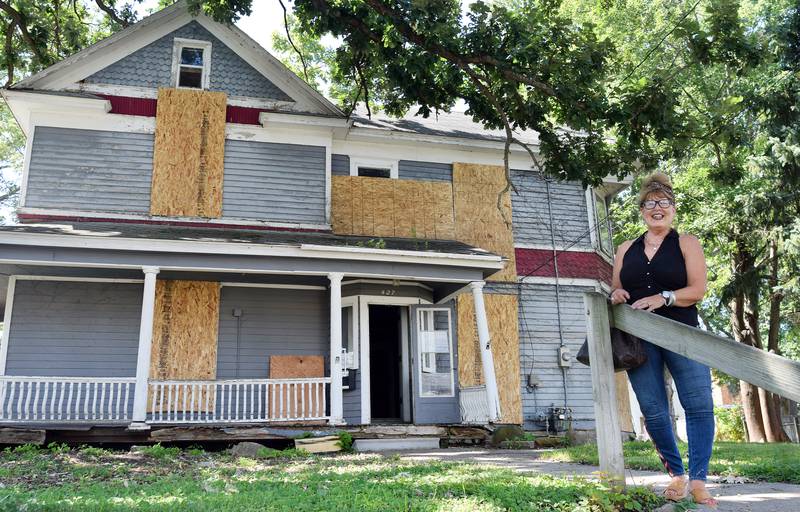 Nancy Sorbella of Carmel, N.Y., stands outside the 112-year-old property at 427 N. Third Ave. E. in Newton. Sorbella says she has become obsessed with the home, which belonged to her family at one point, and she wants to restore it back to life.