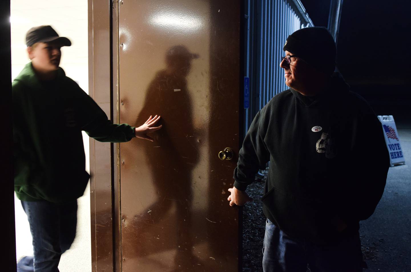 Michael Wood, a Libertarian candidate running for Iowa House District 38, holds the door open for his son after voting in his precinct at the Jasper County Fairgrounds on Nov. 8 in Colfax.