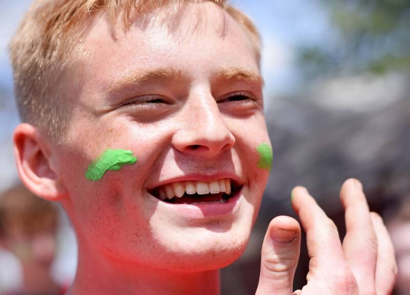 Newton students on May 4 paint their faces before painting Christmas light displays for the city's Maytag Park Holiday Lights during Red Pride Service Day.