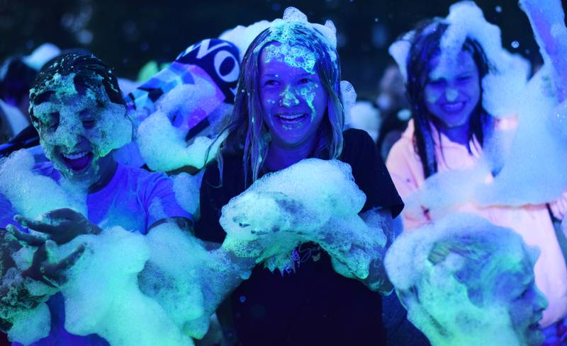 Kids participate in Driving Cap Entertainment's UV Glow Foam Party during Newton Fest on June 9 in Maytag Park in Newton.