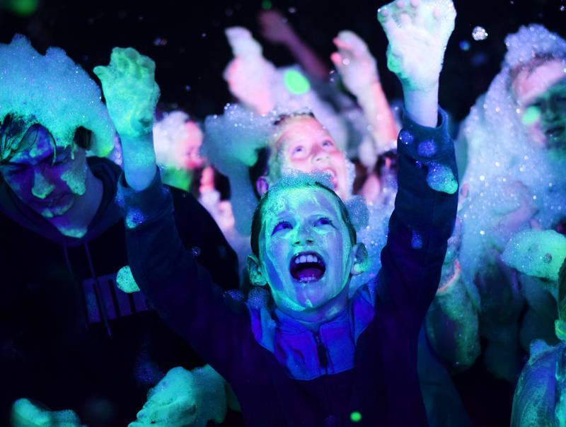 Kids participate in Driving Cap Entertainment's UV Glow Foam Party during Newton Fest on June 9 in Maytag Park in Newton.