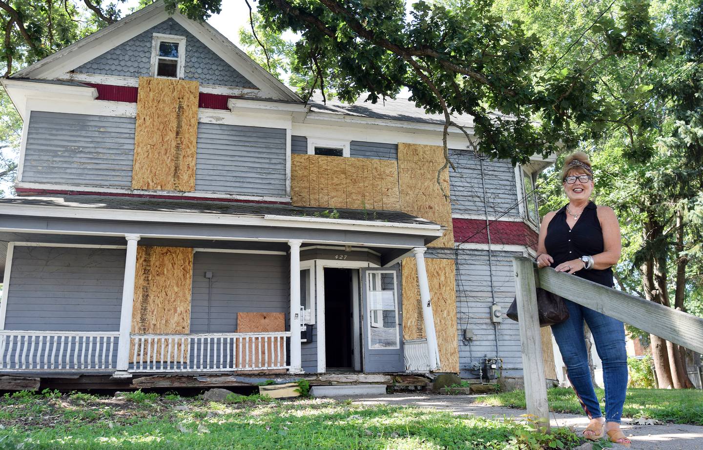 Nancy Sorbella of Carmel, N.Y., stands outside the 112-year-old property at 427 N. Third Ave. E. in Newton. Sorbella says she has become obsessed with the home, which belonged to her family at one point, and she wants to restore it back to life.