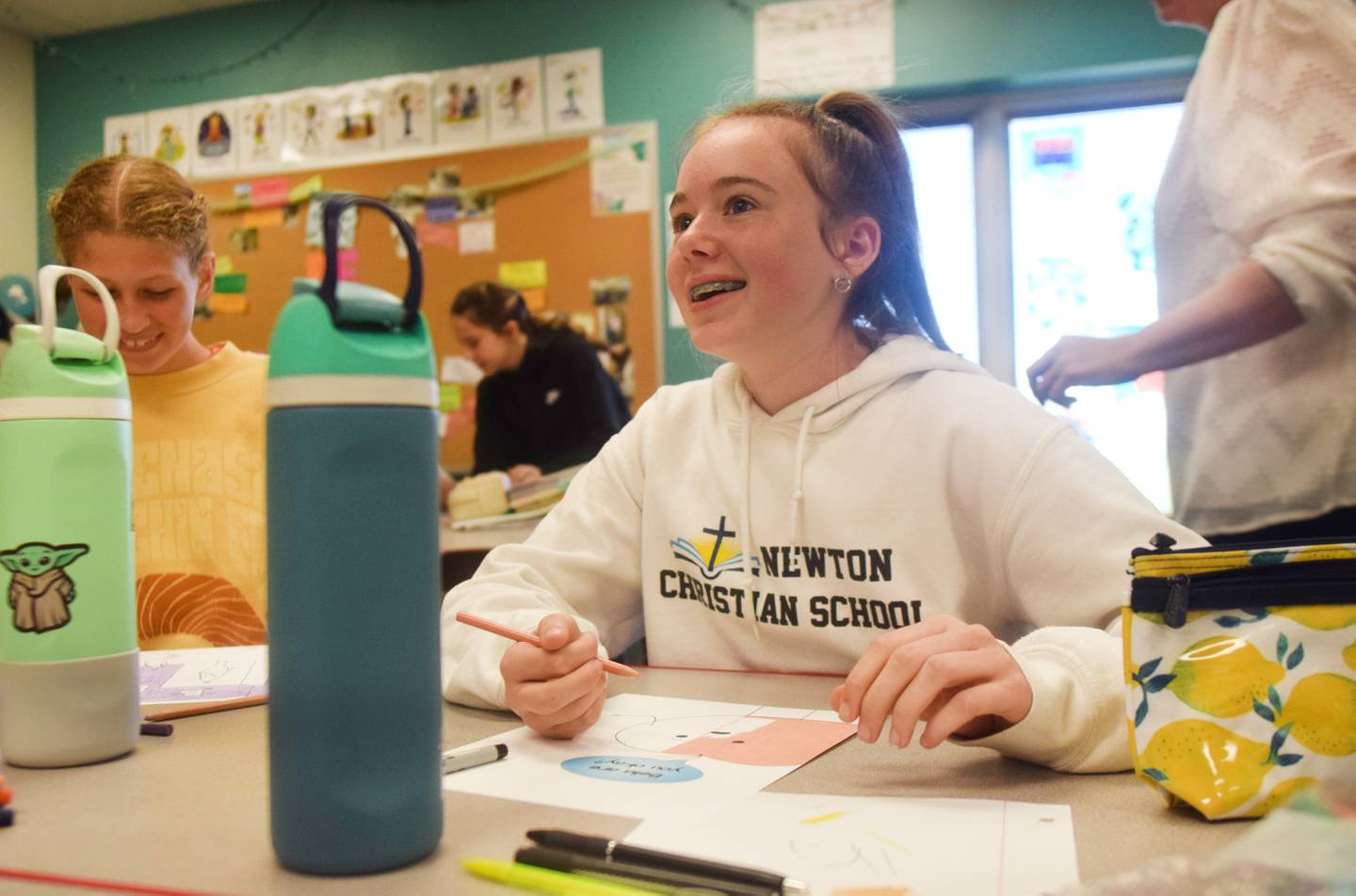 Middle school students of Jessica Moore's classroom in Newton Christian School color in pages of their original children's book, which is going to be on display at the StoryWalk in Agnes Patterson Park.