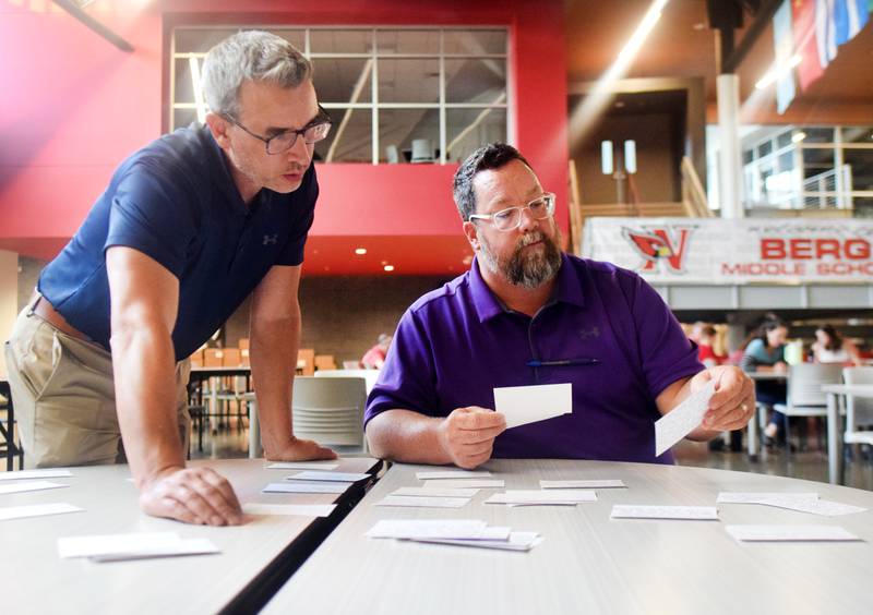 Newton school board members Josh Cantu and Travis Padget sort through and group together questions and comments from an Aug. 15 town hall at Berg Middle School.