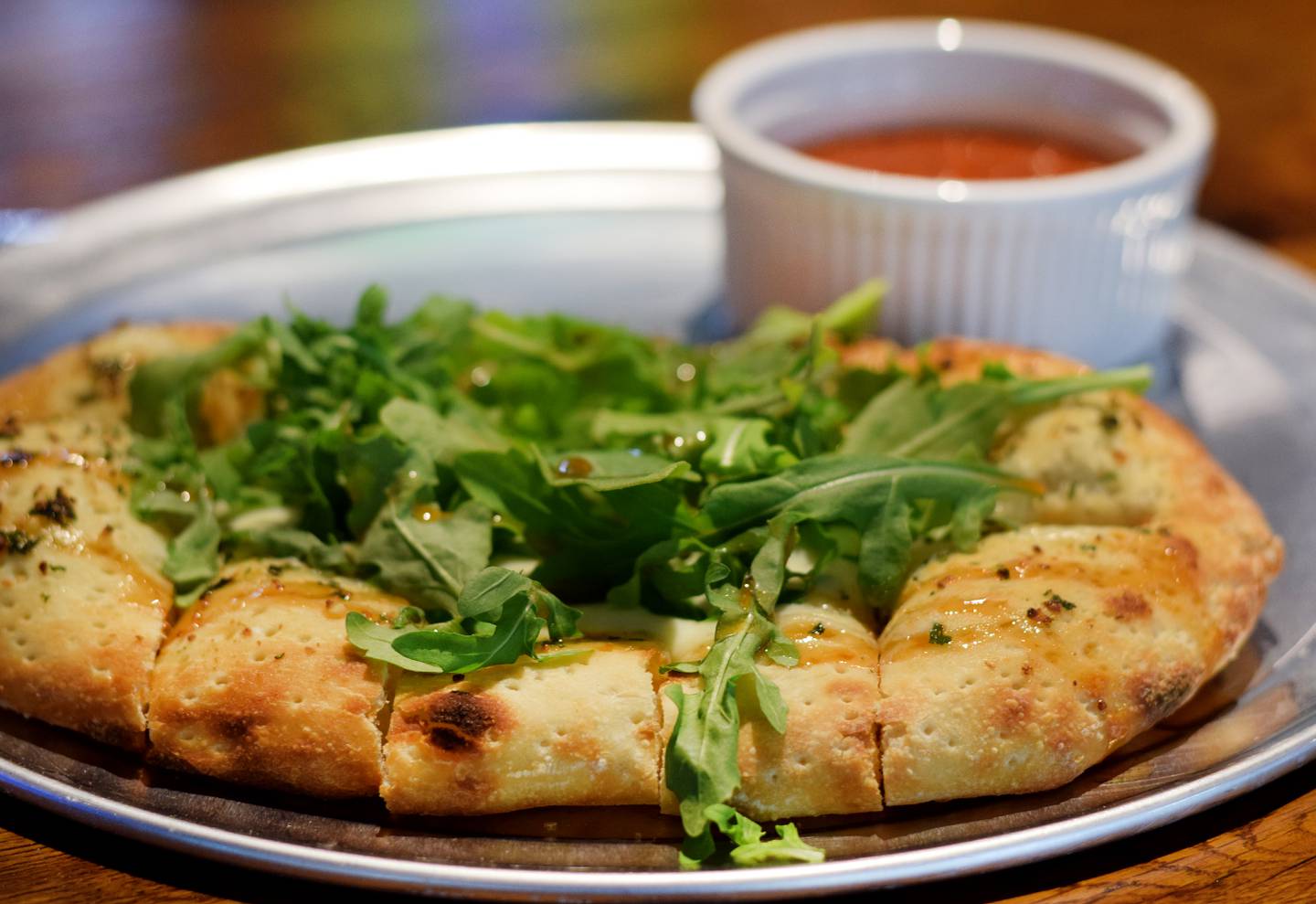 Hot honey garlic cheese bread is topped with arugula and served with homemade marinara sauce at Murph & Mary's Pub. The appetizer is made with the same fermented dough as the pizzas.