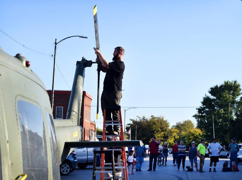 Crews from Midwest Aerospace prepare a Huey helicopter monument while onlookers watch on Sept. 30 in Baxter.