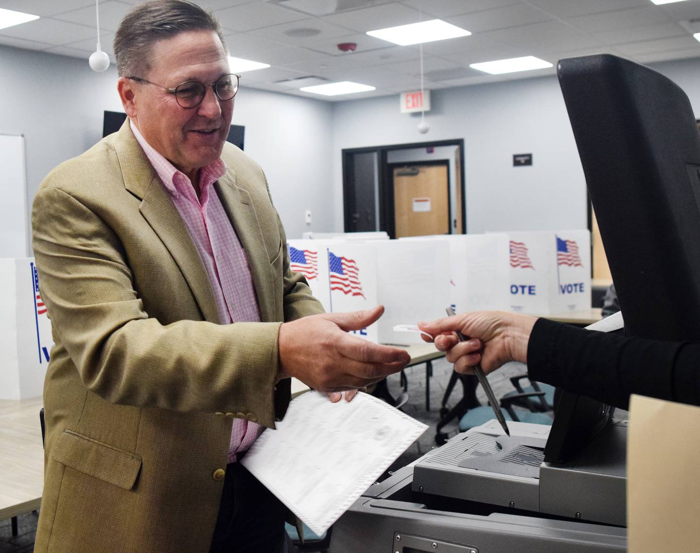 Rep. Jon Dunwell, the Republican incumbent running for Iowa House District 38, receives his sticker after voting at the precinct in the Jasper County Administration Building on Nov. 8 in Newton.