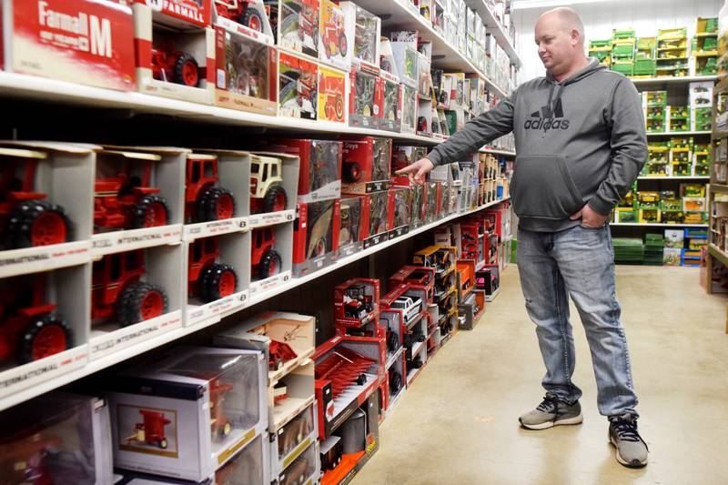 Jason Dalton, owner of Mow Power Dalton's Farm Toys, shows off the different kinds of tractors on display at his new storefront at 3362 Highway 6 East in Newton. Dalton's Farm Toys hosted its grand opening recently that attracted close to 700 people.