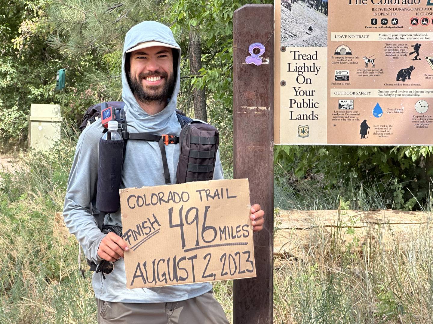 Brady Geilenfeldt, 23, holds up a sign that shows he finished the Colorado Trail on Aug. 2, which was to commemorate a departed friend and to inspire others who are deaf or hard of hearing that they are not limited by their abilities.