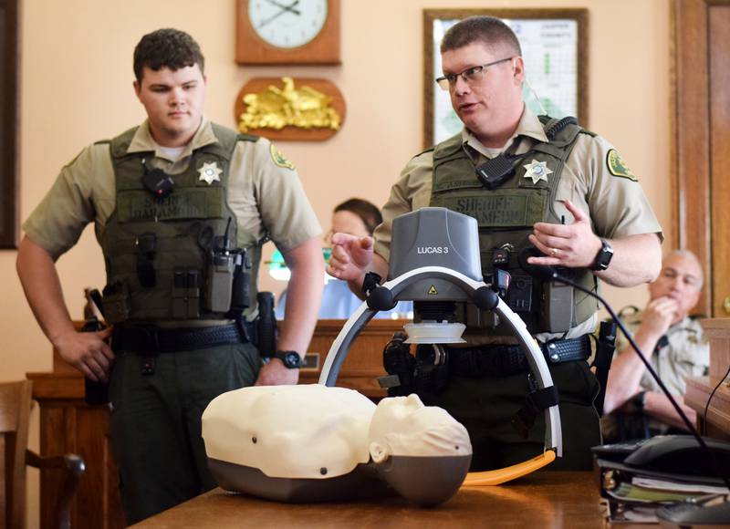 Reserve deputy paramedic Steve Ashing, right, showcases the LUCAS device May 10 during the Jasper County Board of Supervisors meeting.