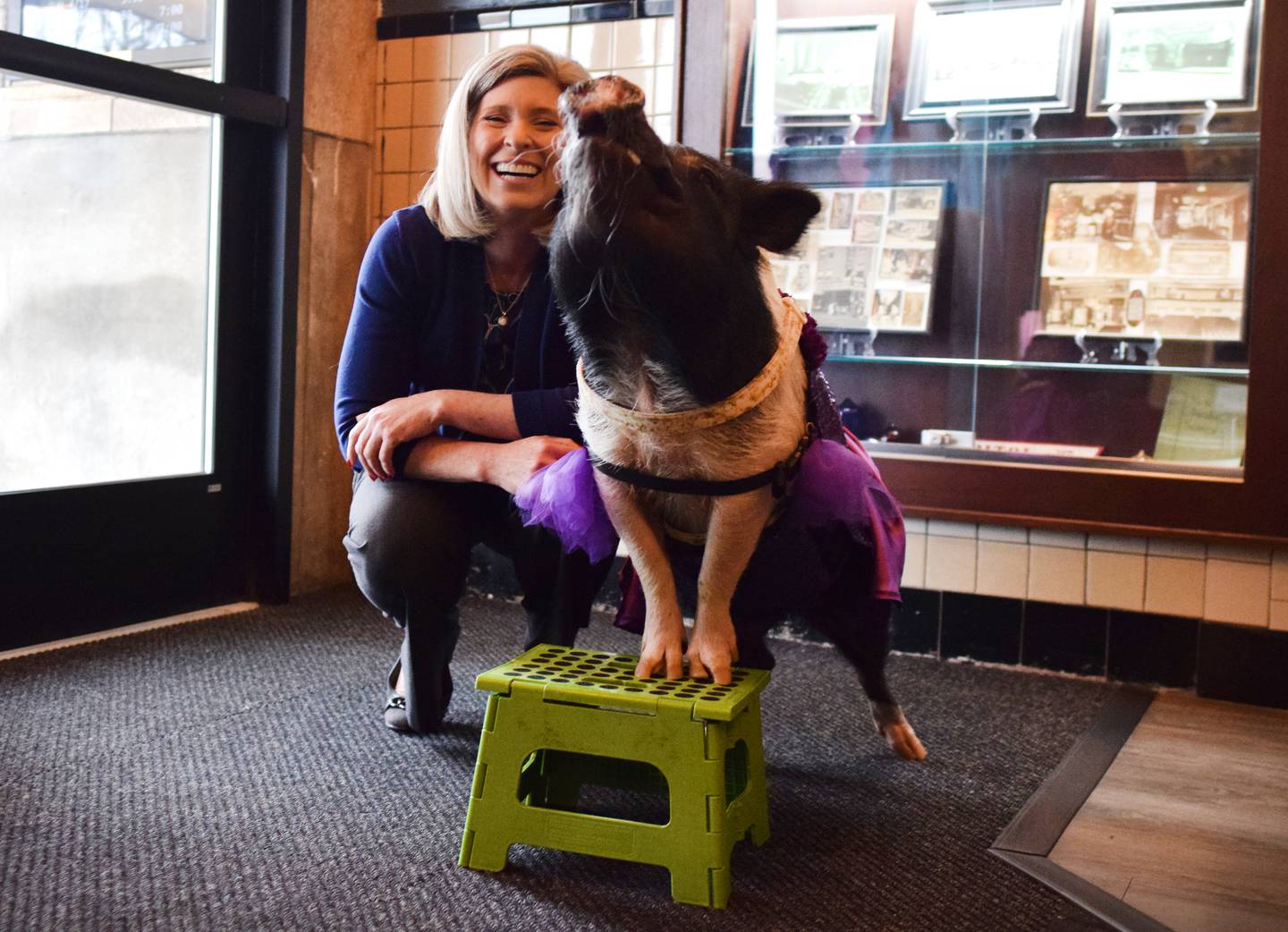U.S. Sen. Joni Ernst, R-Iowa, poses for pictures with Joy the mini-pig, the mascot of the Capitol II Theatre, on April 20 in Newton.