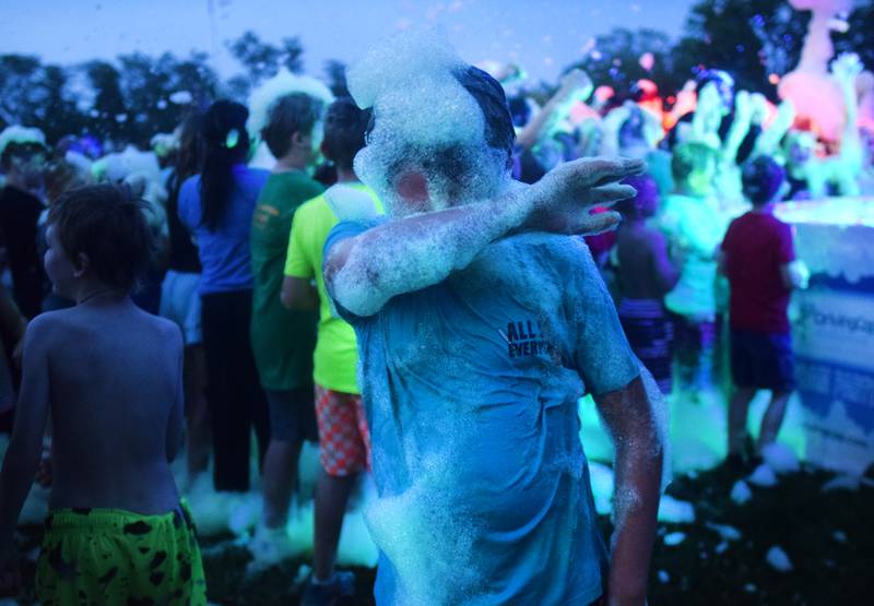 Kids participate in Driving Cap Entertainment's UV Glow Foam Party during Newton Fest on June 9 in Maytag Park in Newton.