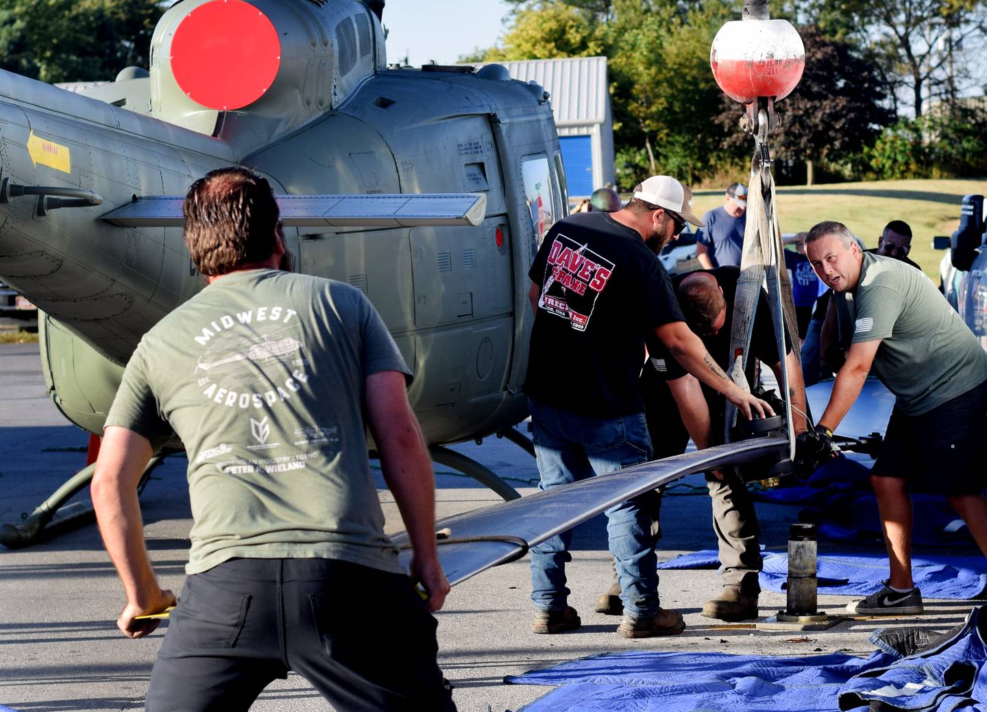 Crews from Midwest Aerospace and Dave's Crane & Wrecker Service help lift the main rotor blade to a Huey helicopter on Sept. 30 in Baxter.