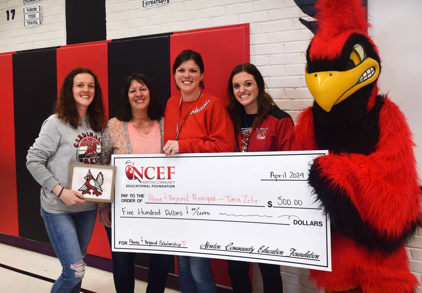 Tara Zehr, principal of Emerson Hough Elementary School, poses for a picture with family members after receiving the Above & Beyond Award from Newton Community Educational Foundation and a $500 schoolarship to give to a senior next month.