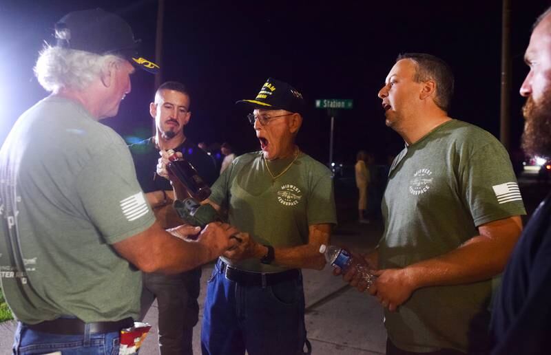 Lynn Harnden, a retired Lt. Colonel of the U.S. Army, reacts when receiving a commemorative bottle of whiskey from Joe Giannini of Midwest Aerospace, the company that supplied and assembled the Huey helicopter memorial.
