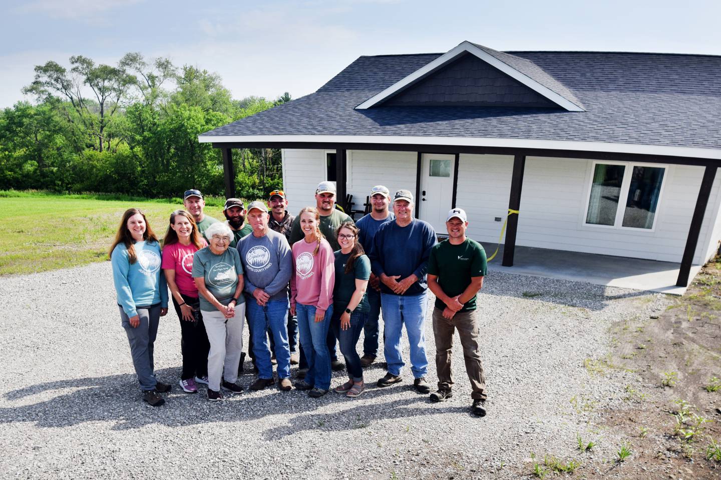Jasper County Conservation staff and board members pose for a picture outside the Coneflower Cottage, a new cabin at Mariposa Park that is available for rent.