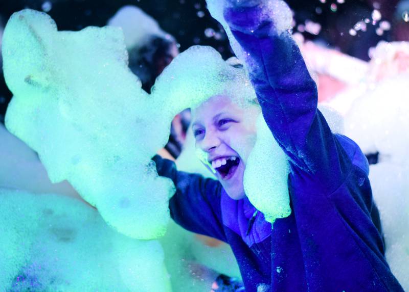Kids participate in Driving Cap Entertainment's UV Glow Foam Party during Newton Fest on June 9 in Maytag Park in Newton.