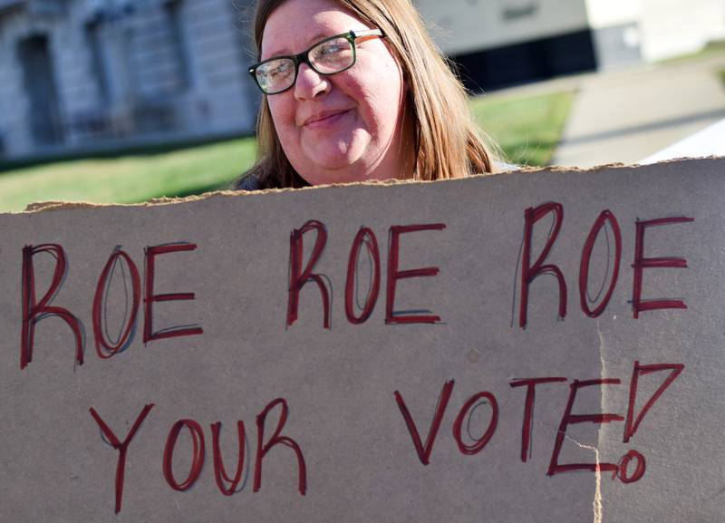 Michelle Smith, of Mingo, displays a sign advocating for women's rights during a demonstration on Oct. 22 near the town square of Newton.