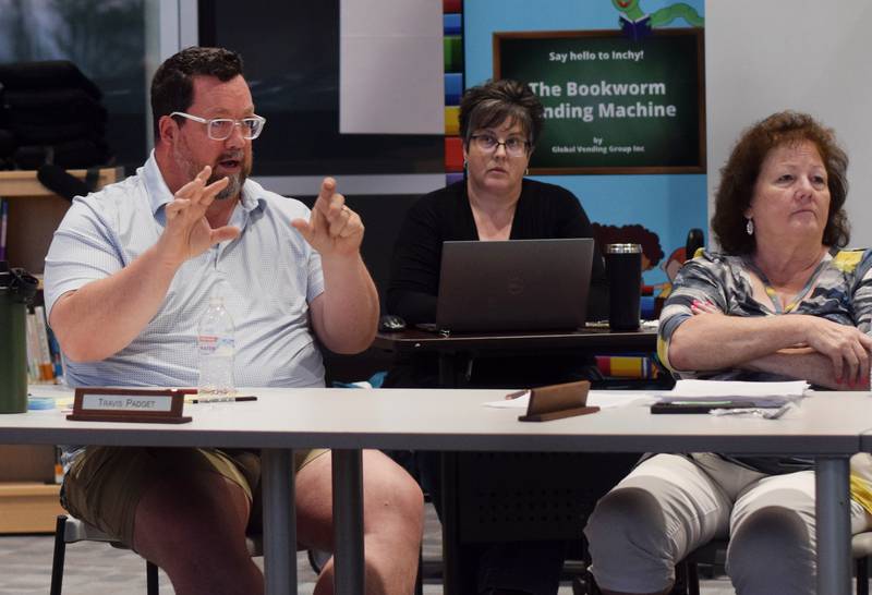 School board member Travis Padget, left, speaks during the June 26 meeting at Berg Middle School. Padget voted against a state-mandated policy that requires Newton school district employees to report whether students go by a different nickname, pronoun or gender identity than what was reported on their documents entering the school year.