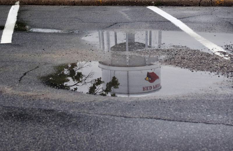 The Newton water tower is seen in the reflection of a pool of water gathered in a public parking lot. The city council on July 1 passed the first of three readings for a stormwater utility rate increase.