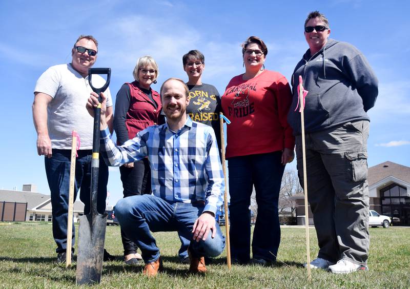 From left: Mark Thayer, Newton Mayor Evelyn George, Bryce Heitman (front), Newton Main Street Executive Director Erin Yeager, Emily Thomason and city parks operations assistant superintendent Jamie Murphy pose for a photo on the land that will soon become the splash pad park, known colloquially as Harmony Park.