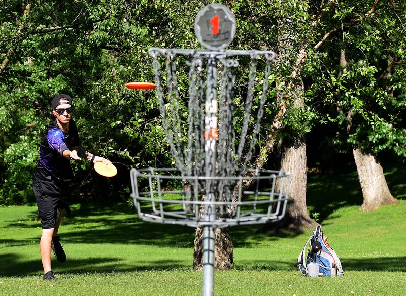 A disc golfer plays a hole at Maytag Park. The Newton City Council voted in favor of providing more holes to the Woodland Park disc golf course in order to make it more attractive for competitive play.
