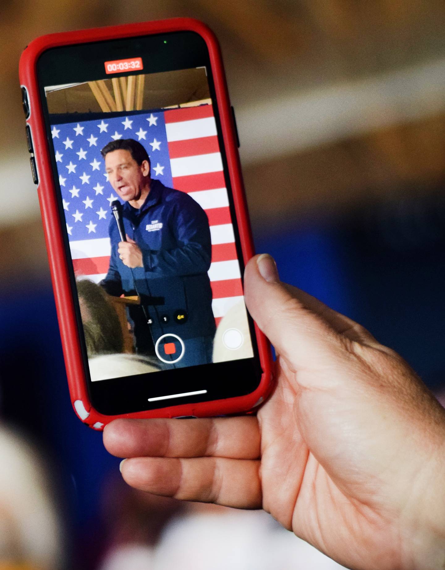 A guest uses an iPhone to record a speech by Florida Gov. Ron DeSantis, who is running for president, during a campaign stop Dec. 2 at The Thunderdome in Newton. DeSantis finished his 99-county tour in Jasper County with support from local legislators, the governor of Iowa and the leader of an influential conservative group.