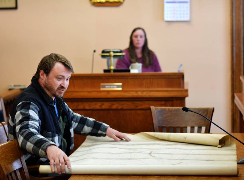Joe Otto unrolls a large drainage district map, which he plans to digitize and provide a digital copy to Jasper County at no cost. The map is more than a 100 years old.