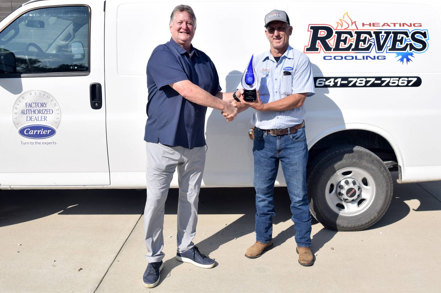 From left: John Lepic, territory manager of Carrier Enterprise Central Plains, shakes hands with Jack Reeves, owner of Reeves Heating & Cooling, who received the Carrier President's Award this year.