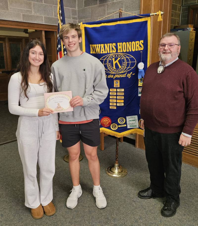 Alyssa Beerends and Garrett Snook are the Newton Noon Kiwanis students of the month for November. Kiwanis president, Capt. Tim North presents a book to the students that will be donated to a local preschool.