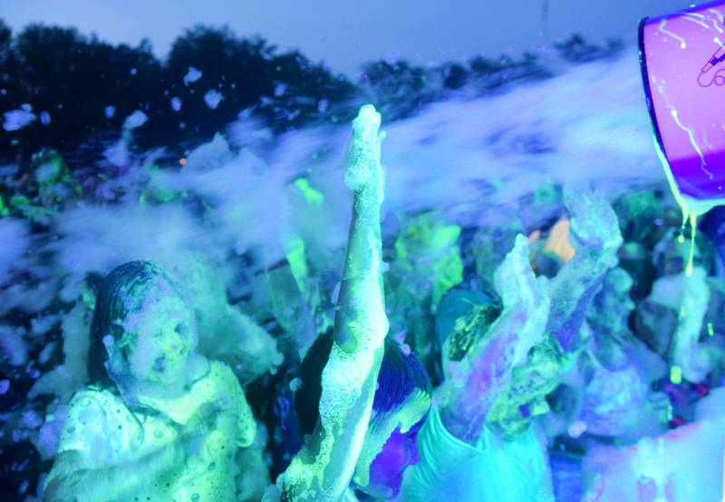 Kids participate in Driving Cap Entertainment's UV Glow Foam Party during Newton Fest on June 9 in Maytag Park in Newton.