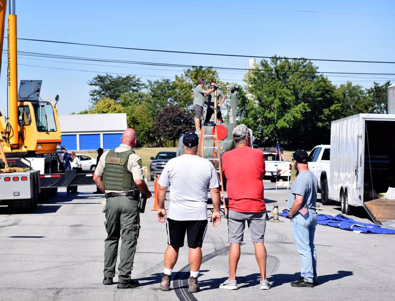 Onlookers watch the progress of the Huey helicopter memorial on Sept. 30 in Baxter.