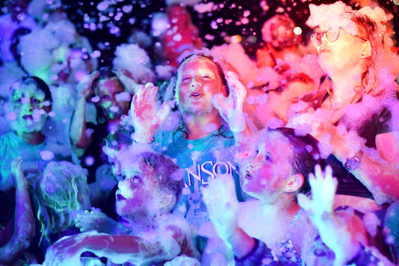 Kids participate in Driving Cap Entertainment's UV Glow Foam Party during Newton Fest on June 9 in Maytag Park in Newton.