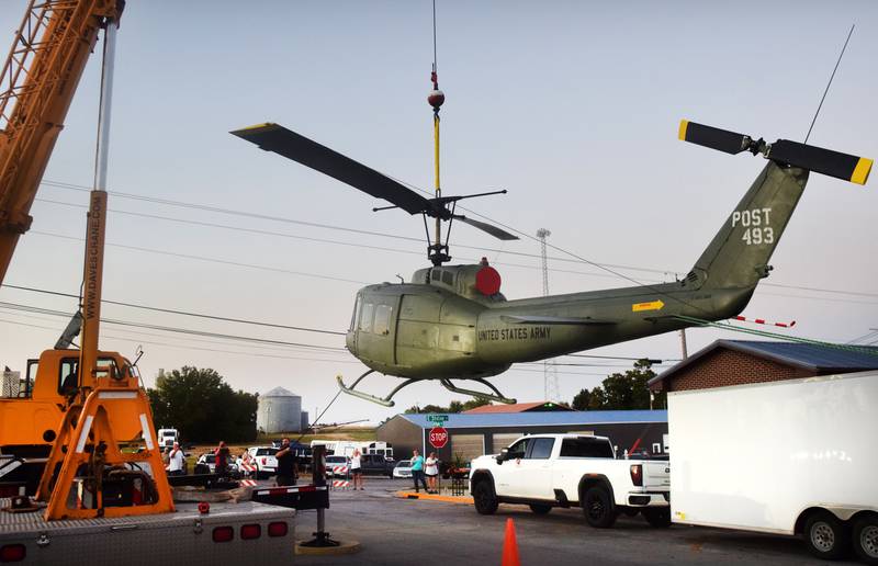 Dave's Crane & Wrecker Service help lift the Huey helicopter onto its raised platform on Sept. 30 in Baxter.