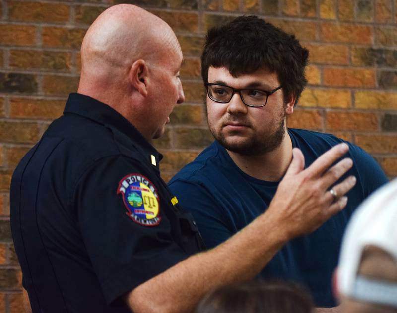 Noah Petersen, right, is told to keep order by Newton Police Lt. Chris Wing after disrupting the city council meeting with comments condemning the police department. Petersen's comments were in reference to the false arrest of 19-year-old Tayvin Galanakis.