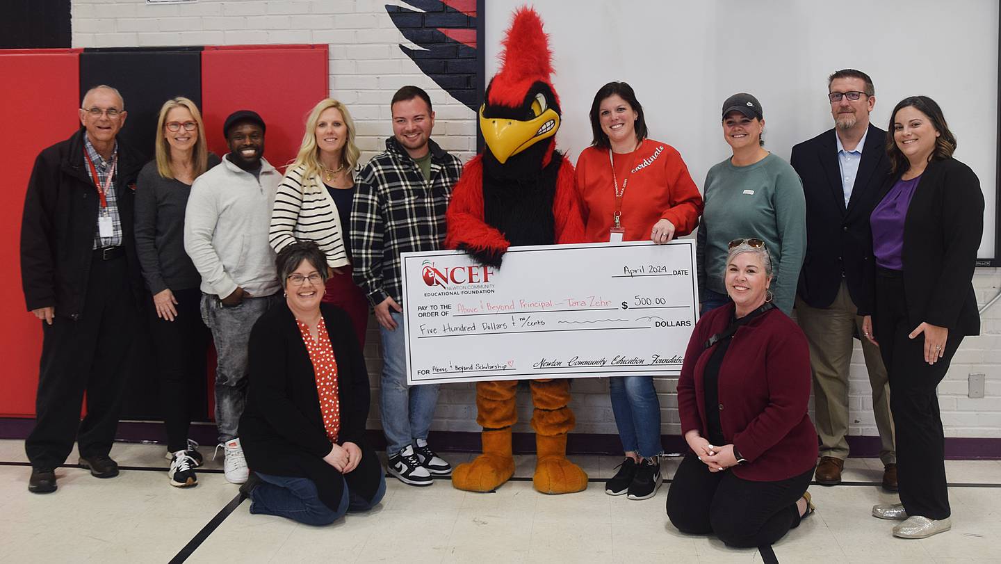 Newton Community School District administrators and members of Newton Community Educational Foundation pose for a picture after Tara Zehr, principal of Emerson Hough Elementary School, received the Above & Beyond Award.