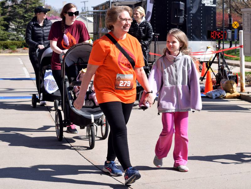 Runners, walkers and young bikers take off for the Run For Her Life 5K organized by nonprofit Phoenix Phase Initiative on April 29 at Legacy Plaza in Newton.