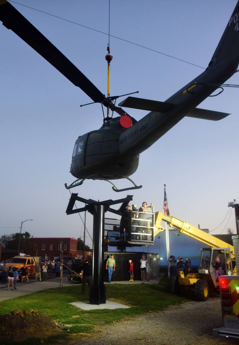 Dave's Crane & Wrecker Service help lift the Huey helicopter onto its raised platform on Sept. 30 in Baxter.