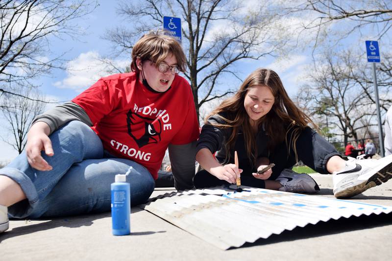 Newton students on May 4 painted Christmas light displays for the city's Maytag Park Holiday Lights during Red Pride Service Day.