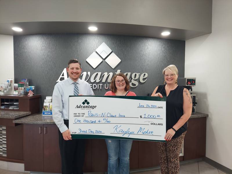 Jeff Holschuh and Cammy Sherman from Advantage Credit Union, present a check to Rachel Long, center, from Paws-N-Claws Iowa.