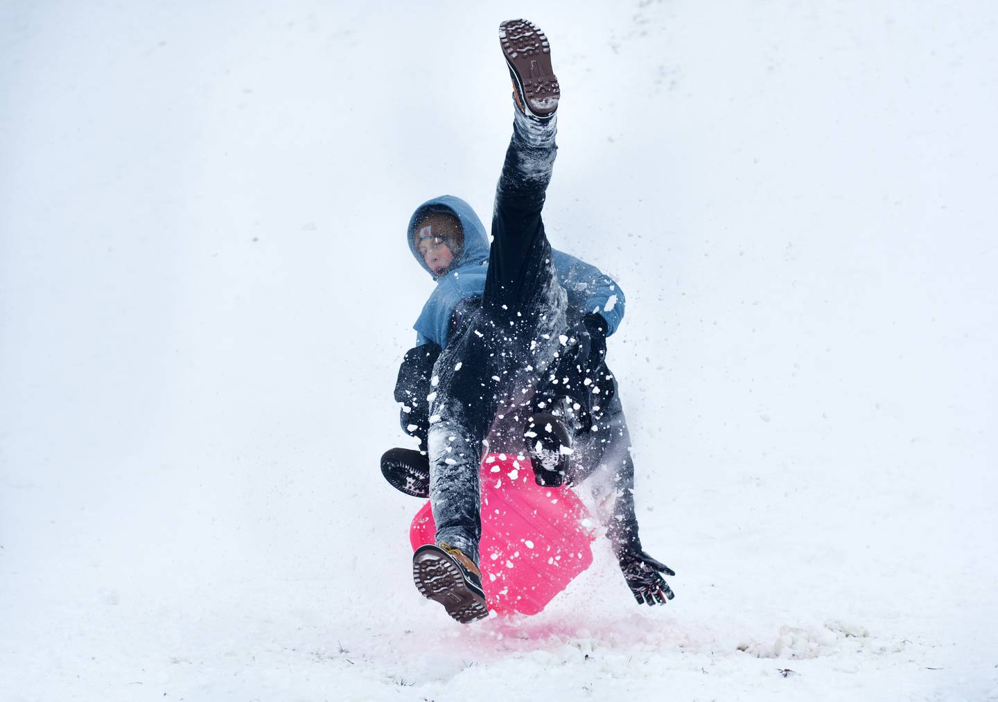 Kolten Slycord and Devin St. John are a tangled mess of arms and legs after hitting a ramp of snow while sledding at Sunset Park on Sunday, Nov. 30 in Newton.