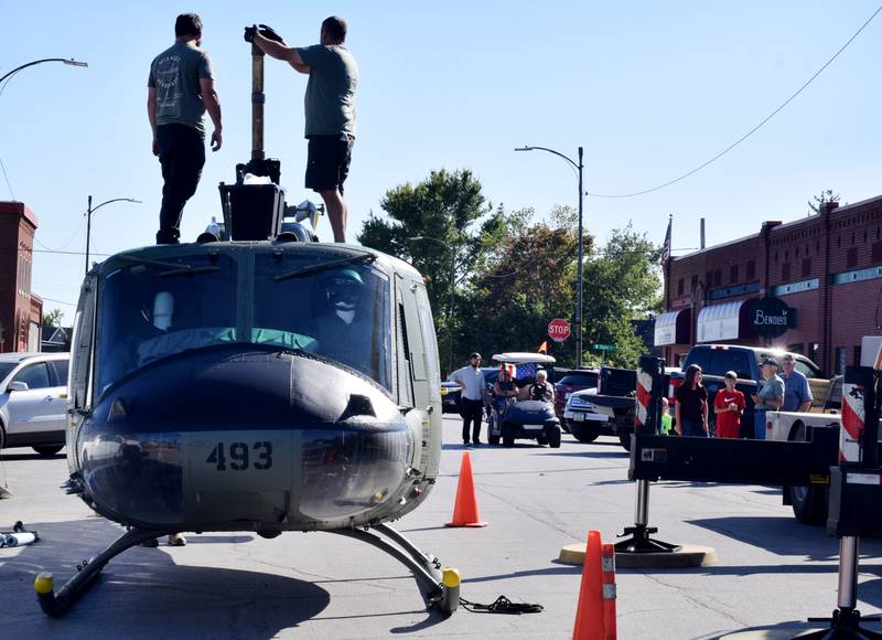 Crews from Midwest Aerospace prepare a Huey helicopter monument while residents watch the progress on Sept. 30 in Baxter.
