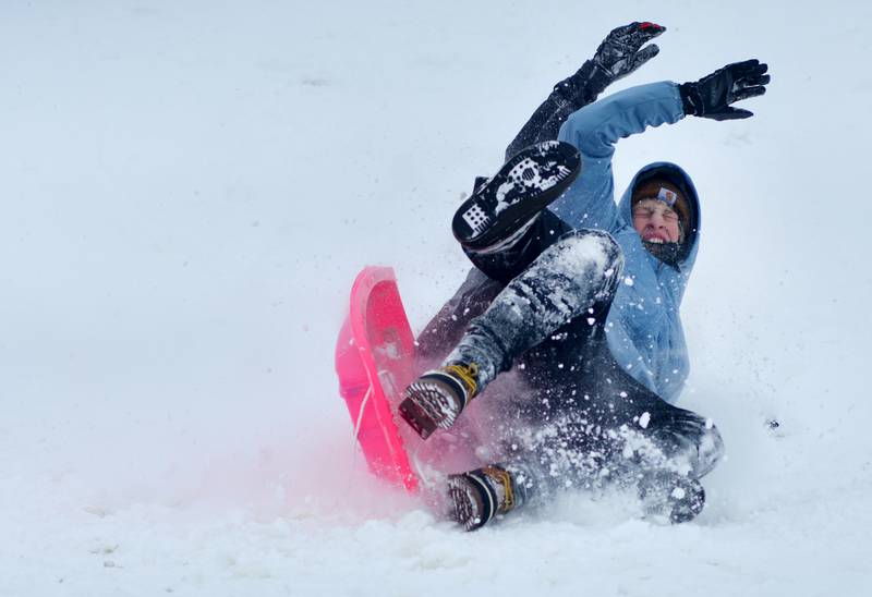 Kolten Slycord and Devin St. John are a tangled mess of arms and legs after hitting a ramp of snow while sledding at Sunset Park on Sunday, Nov. 30 in Newton.