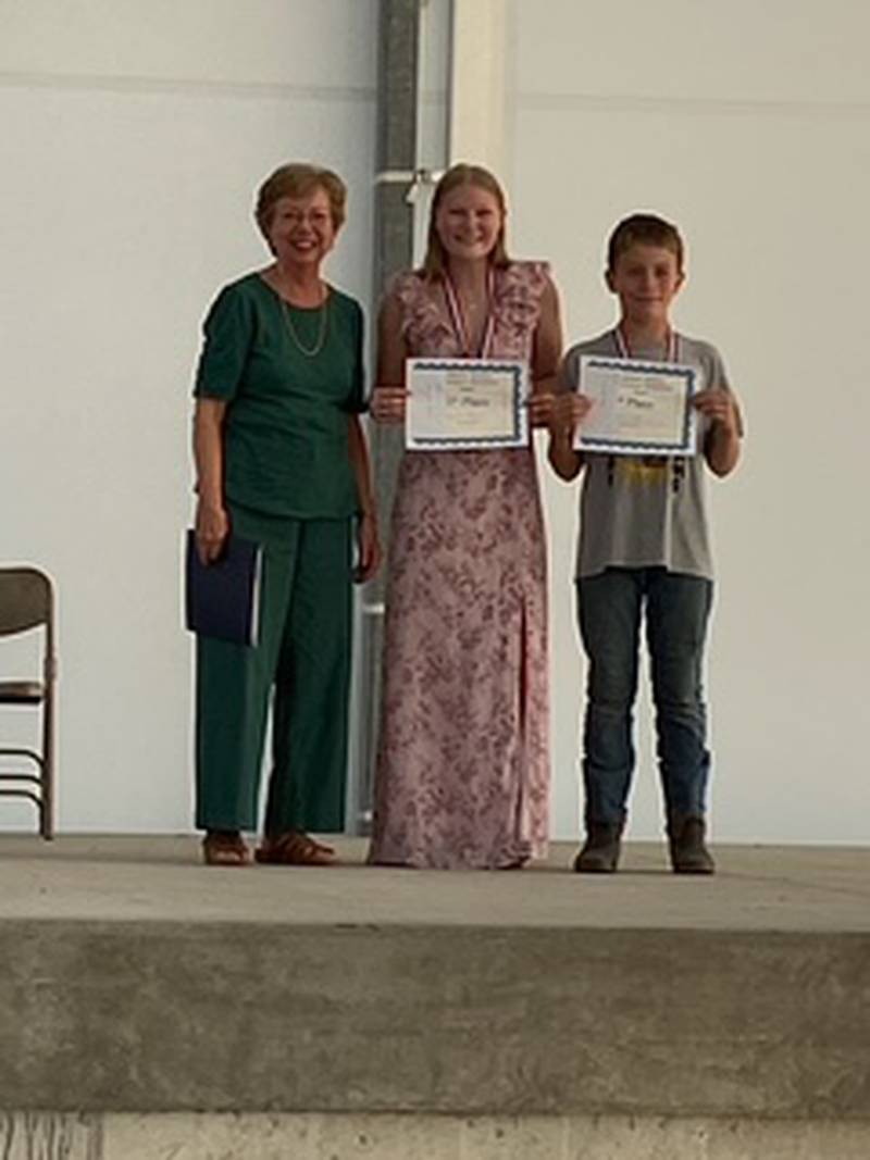 Judy Swenson presents awards to Trinity Ann Hanson and Kandin Meyer at the Jasper County Fair.