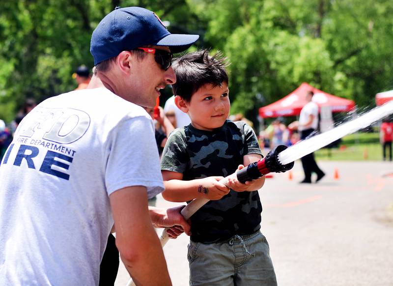 Kids participate in obstacle courses and take a try at the fire hose during Safety Fest on June 8 in Maytag Park. Safety Fest is regularly organized by the Newton Fire Department.