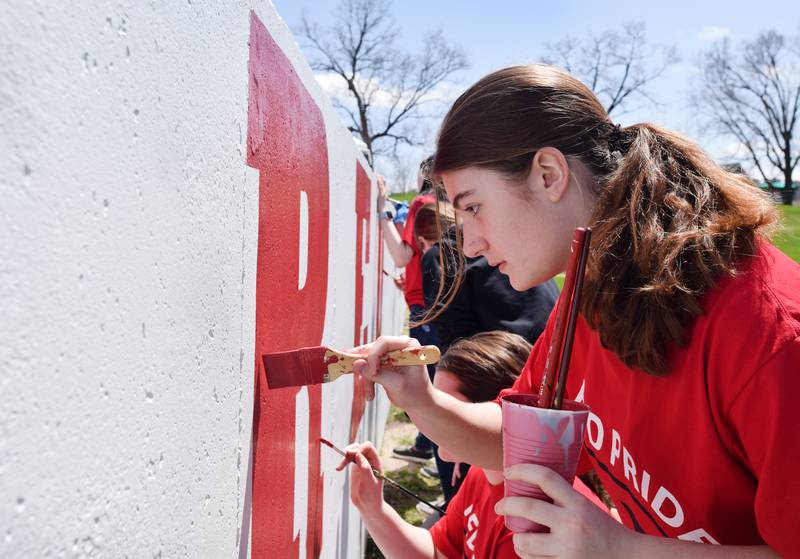 Students paint a mural during Red Pride Service Day on May 4 at Sunset Park in Newton.