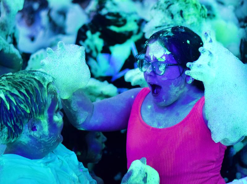 Kids participate in Driving Cap Entertainment's UV Glow Foam Party during Newton Fest on June 9 in Maytag Park in Newton.