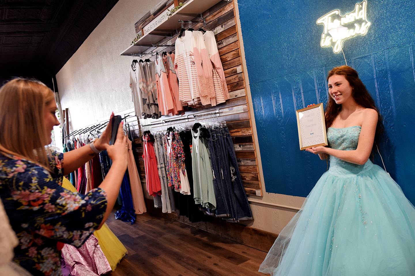Cassidy Thompson, 16, of Albia High School poses with a sign that says, "I said yes to my prom dress," during a free prom dress giveaway event on March 16 at Daughters Boutique Color Bar & Beauty Salon in Newton.